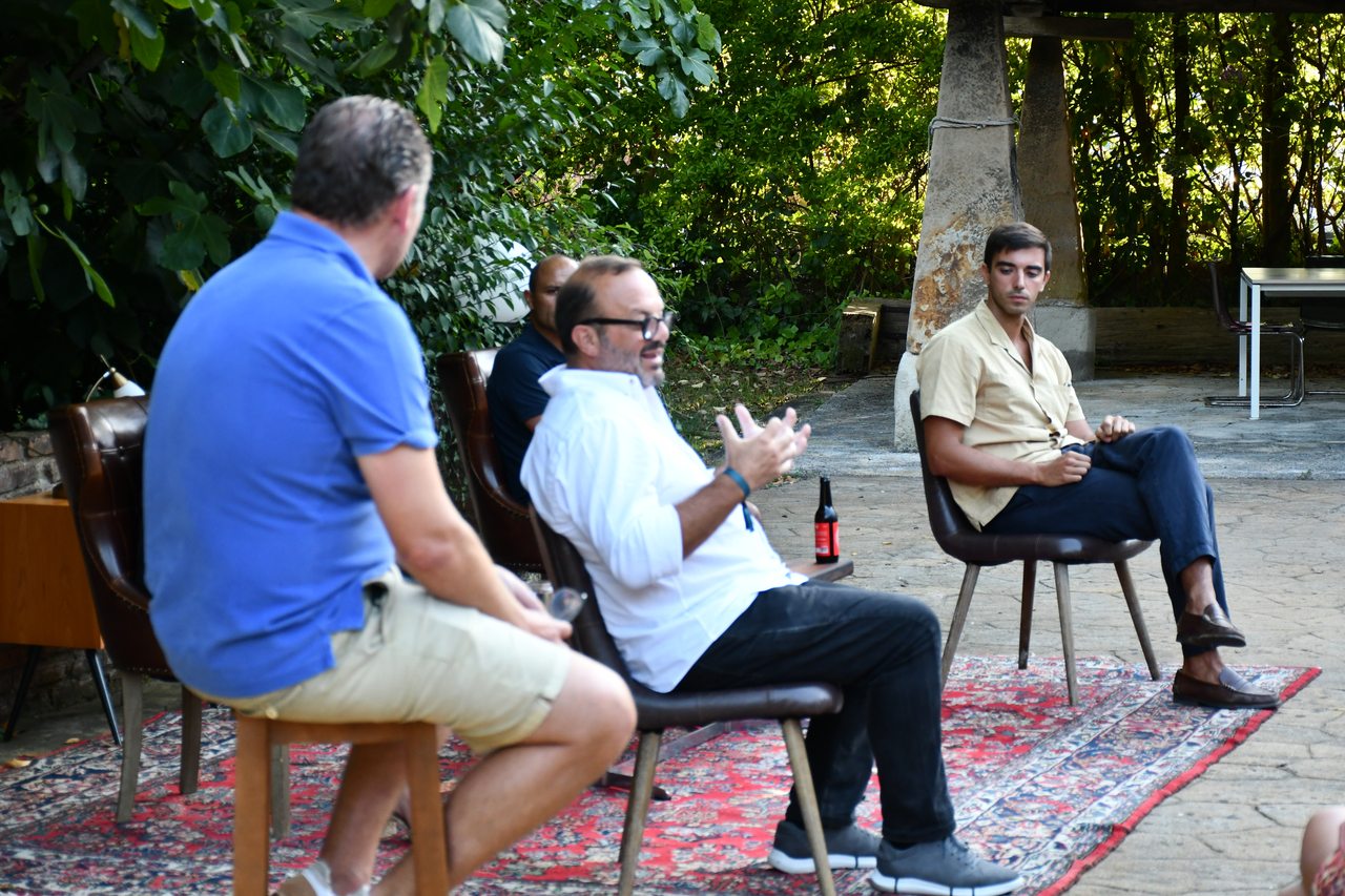 Three panel participants exchange ideas in an outdoor conversation at Diáspora